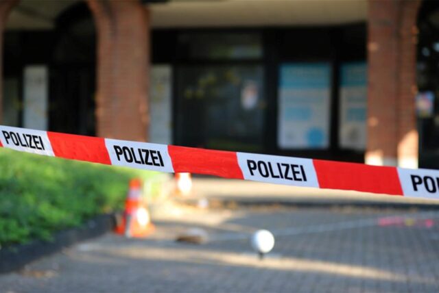 Absperrung der Polizei, im Hintergrund ein Haus.