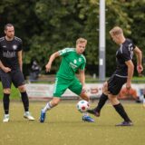 Drei Fußballer kämpfen um den Ball.
