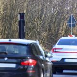 Autos fahren an einem Blitzer vorbei.