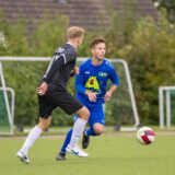 Zwei Fußballer rennen einem Ball hinterher.