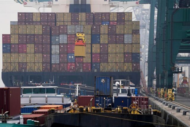 Ein Container wird im Hafen auf ein Schiff verladen.