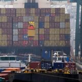Ein Container wird im Hafen auf ein Schiff verladen.