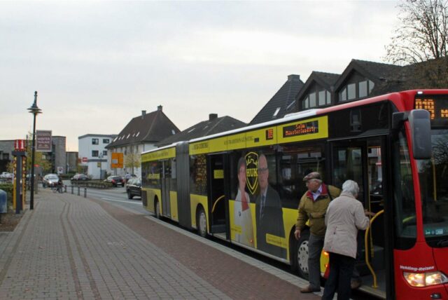 Menschen steigen aus einem Bus der Linie R19 aus.