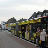 Menschen steigen aus einem Bus der Linie R19 aus.