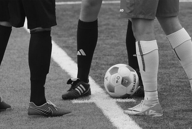Zwei Fußballer am Mittelkreis.
