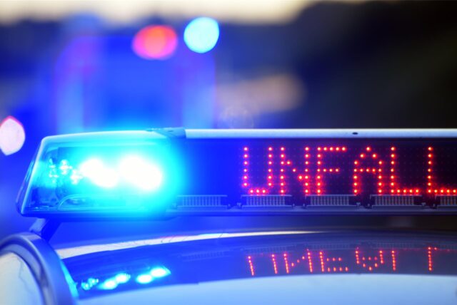 Auf einem Polizeifahrzeug warnt eine Leuchtschrift vor einer Unfallstelle