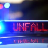 Auf einem Polizeifahrzeug warnt eine Leuchtschrift vor einer Unfallstelle