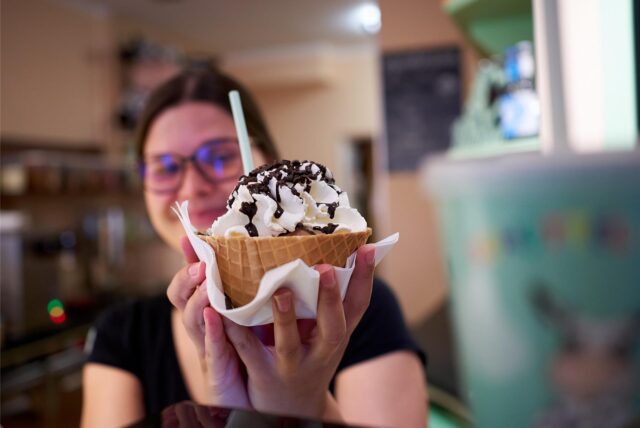 Eine Kuhbar-Mitarbeiterin hält einen Eisbecher in die Kamera. Die Tierrechtsorganisation Peta übt harsche Kritik an dem Eis-Franchise.