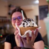 Eine Kuhbar-Mitarbeiterin hält einen Eisbecher in die Kamera. Die Tierrechtsorganisation Peta übt harsche Kritik an dem Eis-Franchise.