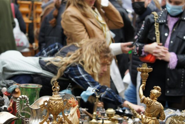 Passanten stöbern auf einem Trödelmarkt in NRW Stände mit Deko und anderen Gebrauchtgegenständen.