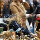 Passanten stöbern auf einem Trödelmarkt in NRW Stände mit Deko und anderen Gebrauchtgegenständen.