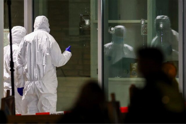 Polizeibeamte mit Schutzanzügen stehen vor dem Cinemaxx-Kino in der Krefelder Innenstadt.