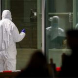 Polizeibeamte mit Schutzanzügen stehen vor dem Cinemaxx-Kino in der Krefelder Innenstadt.