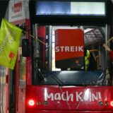 Streikende bringen Verdi-Flaggen an einer Straßenbahn an.