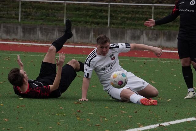 Dominik Kosner spielt den Ball im Liegen.