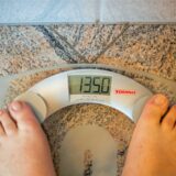 Ein Mensch steht auf einer Waage, die den Wert von 135 Kilogramm zeigt.