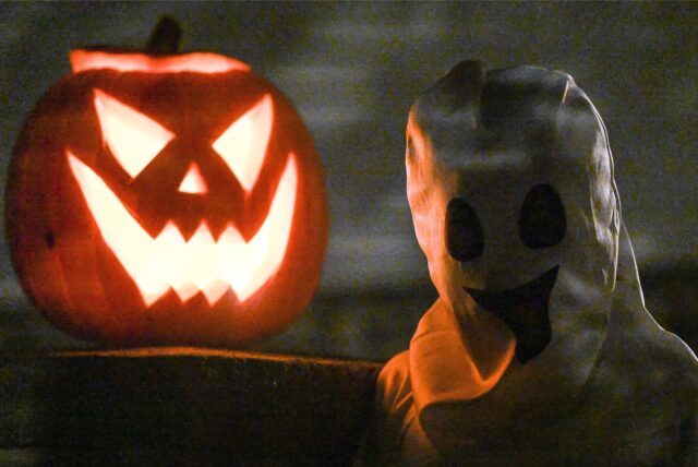 Ein Halloween-Kürbis mit Fratze und ein Geist.