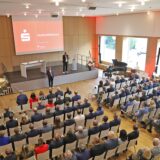 Menschen sitzen im Emschersaal in Holzwickede während einer Veranstaltung der Sparkasse Unna Kamen.