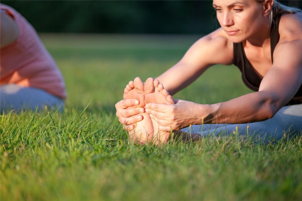 Yoga im Park - eine Frau dehnt sich Yoga im Park - eine Frau dehnt sich
