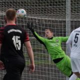 Schaub fliegt und wehrt einen Ball ab. Um ihm herum viele Spieler beider Mannschaften.