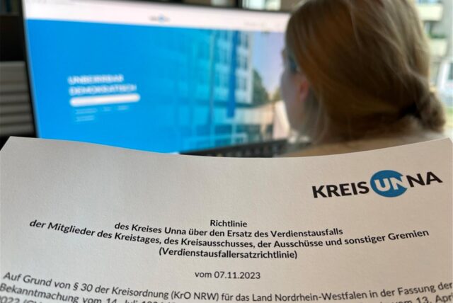 Eine Frau sitzt vor einem Computer und betrachtet die Homepage des Kreises Unna.