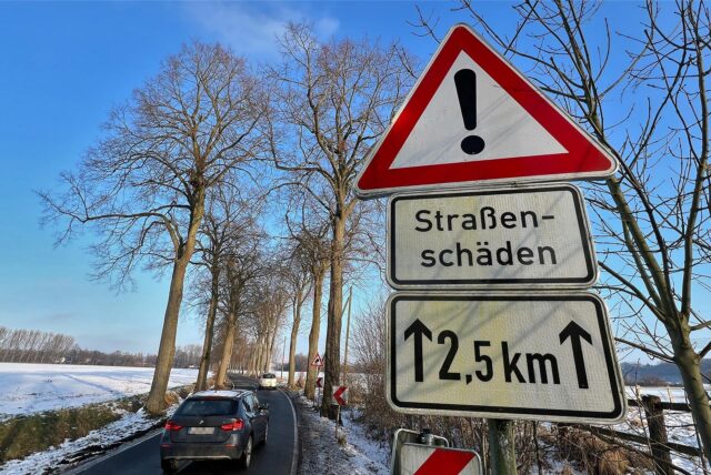 Ein Schild, das auf Straßenschäden hindeutet an der L673