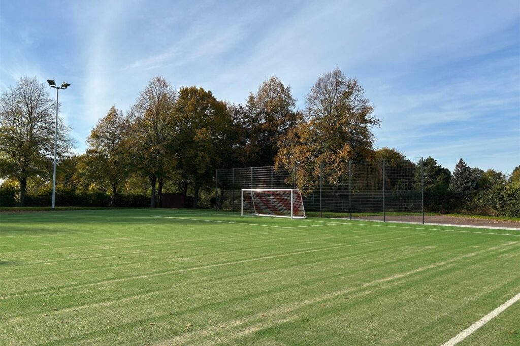 Ein Fußballplatz mit Bäumen im Hintergrund Ein Fußballplatz mit Bäumen im Hintergrund