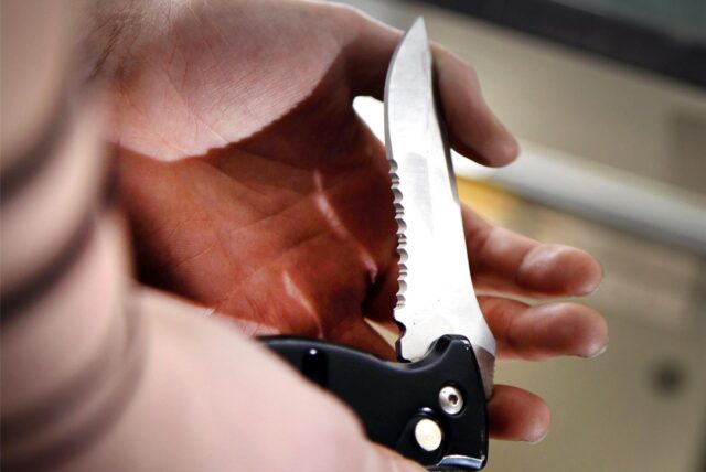 Klappmesser in der Hand eines Mannes.