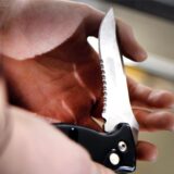 Klappmesser in der Hand eines Mannes.