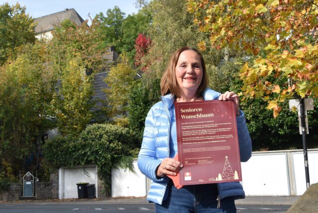 Anette Gospodarek mit Plakat in Fröndenbergs Innenstadt.
