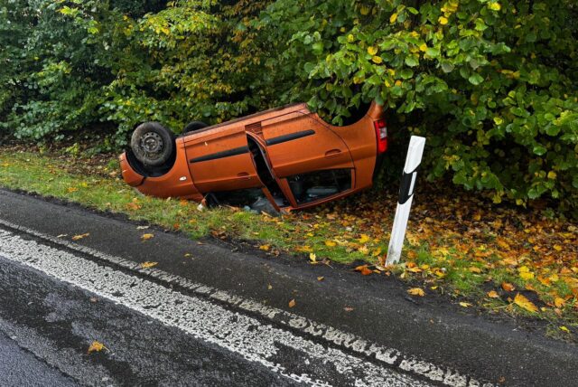 Ein Pkw liegt neben den Fahrspuren des Autobahnkreuzes Dortmund/Unna auf dem Autodach.