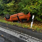 Ein Pkw liegt neben den Fahrspuren des Autobahnkreuzes Dortmund/Unna auf dem Autodach.