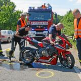 Einsatzkräfte der Feuerwehr helfen nach einem Unfall mit einem Motorrad.