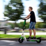 Ein Mann fährt zum Start der E-Tretroller des Anbieters Lime.
