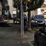 Vor dem Standesamt in Unna sitzen oder stehen Personen an und auf Bänken.