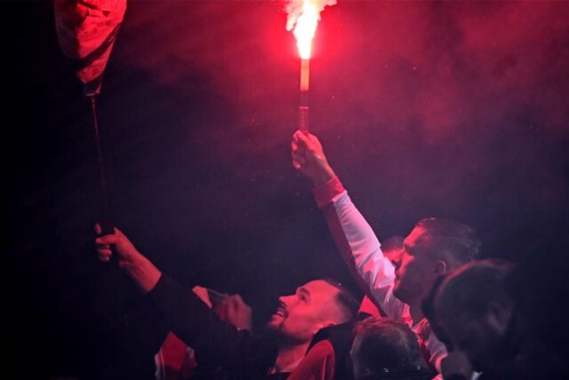 Lukas Podolski mit einer brennenden Pyro-Fackel in der Hand.