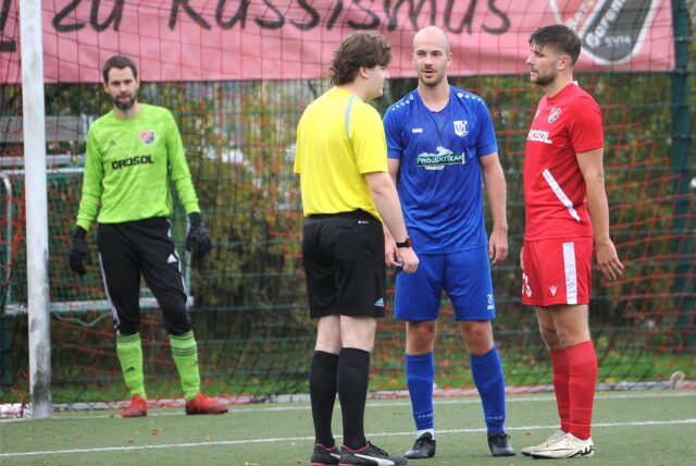Torhüter Manuel Tragelehn beobachtet das Gespräch des Schiedsrichters mit Jan Römmich (VfL Schwerte) und einem Spieler von SC Berchum/Garenfeld.