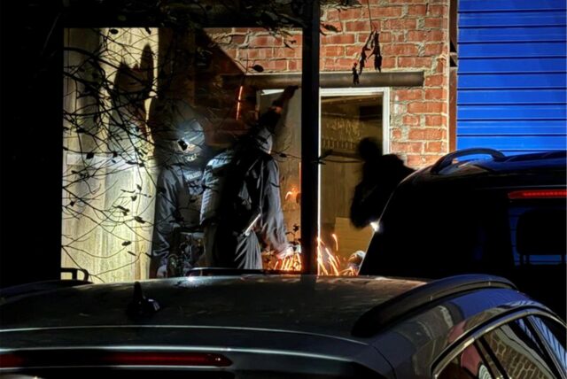 Polizisten schauen in Radevormwald in ein Gebäude. Bei Durchsuchungen wegen bandenmäßiger Steuerhinterziehung in zwei Bundesländern hat die Polizei am frühen Morgen 17 Menschen vorläufig festgenommen.
