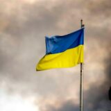Die ukrainische Flagge ist vor dem Rauch eines Feuers zu sehen, nach Angriffen auf die Ukraine über Kiew. Die Gruppe der sieben großen westlichen Industriestaaten gewährt der Ukraine nach Angaben der US-Regierung einen durch Zinserträge aus eingefrorenem russischen Vermögen abgesicherten Kredit in Höhe von 50 Milliarden US-Dollar (rund 46 Milliarden Euro).