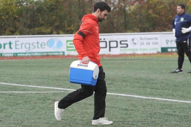 SGE-Trainer Gianluca Zocco läuft mit dem Medizinbehälter aufs Fußballfeld