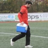SGE-Trainer Gianluca Zocco läuft mit dem Medizinbehälter aufs Fußballfeld