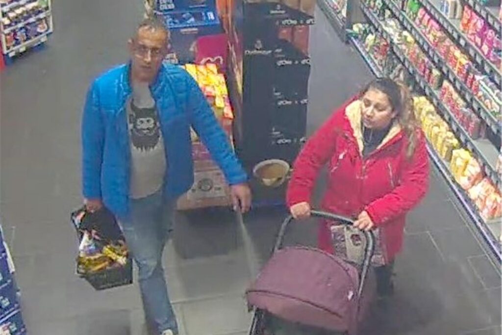Ein Mann mit blauer Jacke und eine Frau mit roter Jacke und einem Kinderwagen gehen durch einen Supermarkt. Das Bild stammt aus einer Überwachungskamera. Ein Mann mit blauer Jacke und eine Frau mit roter Jacke und einem Kinderwagen gehen durch einen Supermarkt. Das Bild stammt aus einer Überwachungskamera.
