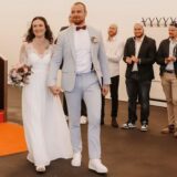 Ein Ehepaar schreitet nach seiner Hochzeit durch ein Spalier seiner Freunde.