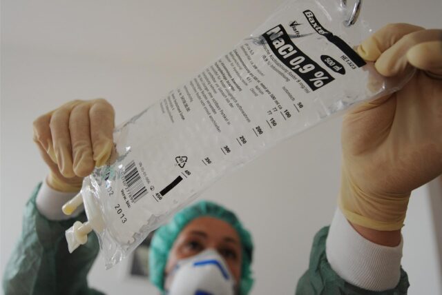 Eine Krankenschwester hängt am Dienstag (24.05.2011) in Hamburg im Marienkrankenhaus in einem Behandlungszimmer eine Flasche mit Kochsalzlösung in einen Infusionsständer.