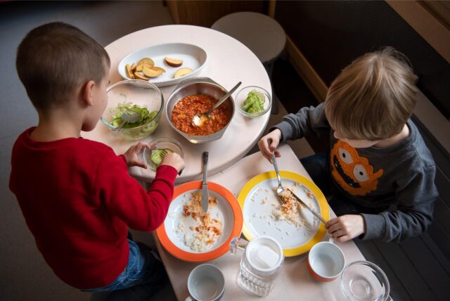 Kinder essen ihr Mittagessen in einer Kindertageseinrichtung