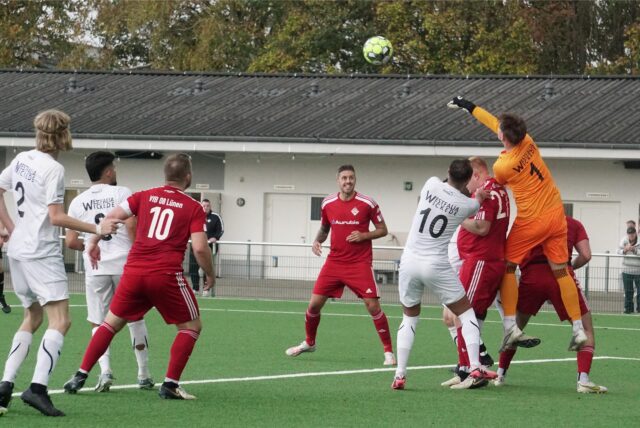 Spieler stehen im Strafraum.