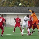 Spieler stehen im Strafraum.