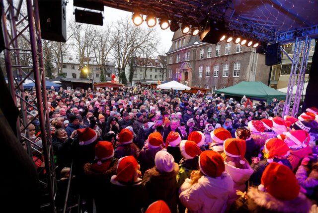 Kinder singen beim Holzwickeder Weihnachtsmarkt auf einer Bühne.