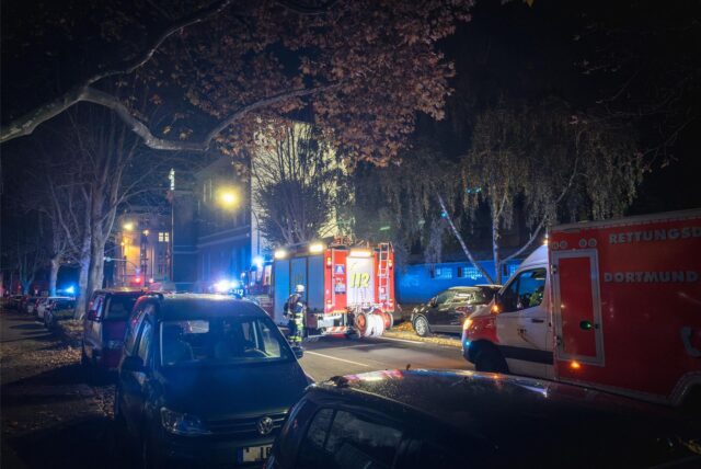 Ein Löschfahrzeug und ein Rettungswagen der Feuerwehr Dortmund stehen auf einer Straße im Dortmunder Hafenviertel