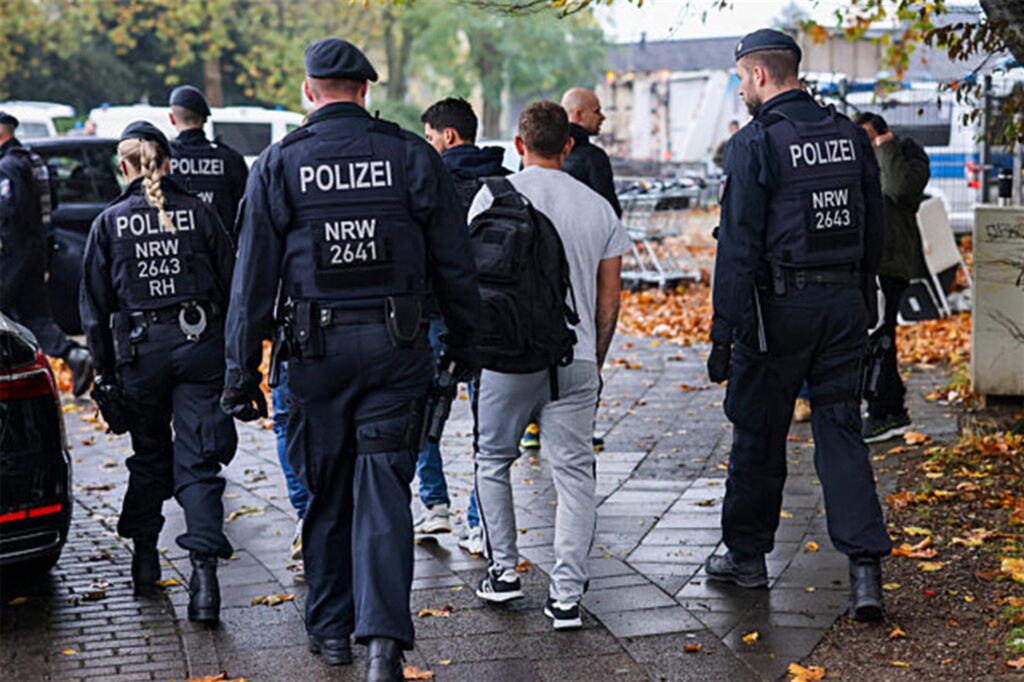 Bei einer Meldekontrolle durch verschiedene Behörden am Problem-Hochhaus «Weißer Riese» im Stadtteil Homberg bringen Polizisten einen Mann zur Überprüfung. Bei einer Meldekontrolle durch verschiedene Behörden am Problem-Hochhaus «Weißer Riese» im Stadtteil Homberg bringen Polizisten einen Mann zur Überprüfung.
